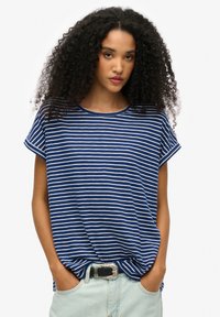 Blauw-wit gestreept t-shirt met korte mouwen, ronde halslijn en een relaxte pasvorm; gecombineerd met lichtblauwe denim broek en een decoratieve riem.