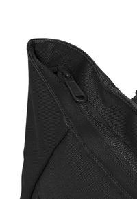 Fekete szövet táska struktúrált felülettel és cipzáras záródással. Ívelt élekkel és letisztult dizájnnal rendelkezik, további minták vagy díszítések nélkül.