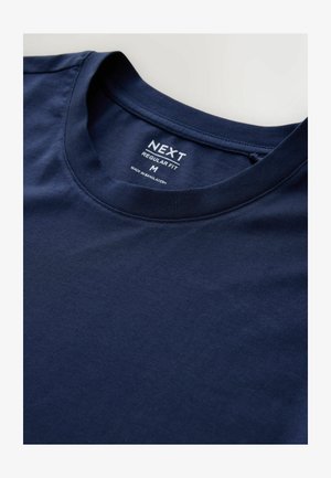 Marinblå bomulds T-shirt med rund halsudskæring, med et tag der læser "NEXT REGULAR FIT M." Glat tekstur, ingen mønstre eller detaljer.