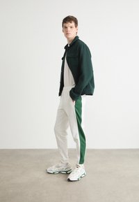 Lacoste Treniņtērpa apakšdaļas - flour/green