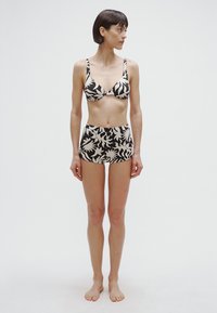 Biquíni preto e creme com padrão floral, composto por um top de soutien moldeado com alças ajustáveis e calções de cintura alta.