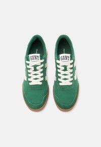 Πράσινα αθλητικά παπούτσια με λευκές ρίγες, κατασκευασμένα από σουέντ και ύφασμα, στ ρογγυλή μύτη, αντίθετη σόλα σε χρώμα καουτσούκ και λευκά κορδόνια. Φέρουν το λογότυπο «GANT» στη γλώσσα.