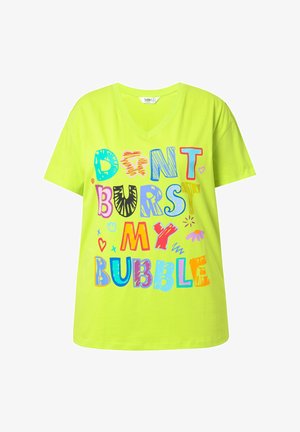 Camiseta verde neón con escote en V y texto colorido: "NO HAGAS ESTALLAR MI BURBUJA," con divertidos estilos y patrones de fuente diversos.