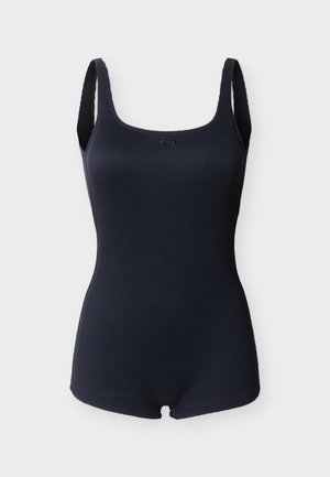 Maillot de bain une pièce bleu marine côtelé avec larges bretelles et petit logo en forme de losange au centre de la poitrine.
