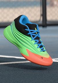 Green and orange athletic shoe with a wavy design, black and blue accents, and textured materials. Features blue laces and logo detail.