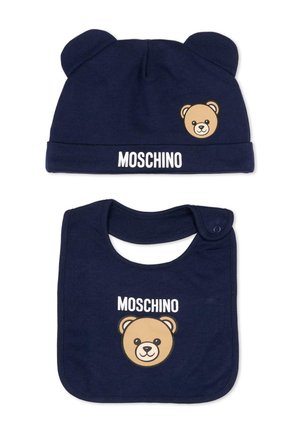 Bonnet bébé bleu marine avec des oreilles d'ours et un bavoir assorti, tous deux avec un visage d'ours et le texte "MOSCHINO" en blanc.