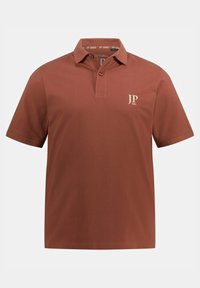 Polo marrone con colletto classico, patta con due bottoni e logo ricamato in beige chiaro sul petto sinistro. Maniche corte, colore uniforme.