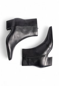 Botines de cuero negro con cierre lateral, diseño angular y tacón ancho. Textura suave y estilo minimalista.