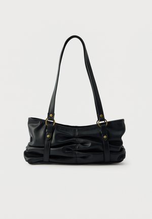 Sac à main en cuir noir plissé avec doubles poignées roulées et accents de quincaillerie en ton or. Texture douce et forme arrondie contribuent à son design.