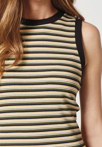 Gestreifter, ärmelloser Pullover mit horizontalen Streifen in Grün, Gelb und Schwarz. Der Ausschnitt ist kontrastierend schwarz. Strukturierte Stoffdetails.