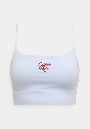 Biely bavlnený bralet s nastaviteľnými ramienkami, so červeným vyšívaným logom "Calvin Klein" na prednej strane a bezšvovým dizajnom.