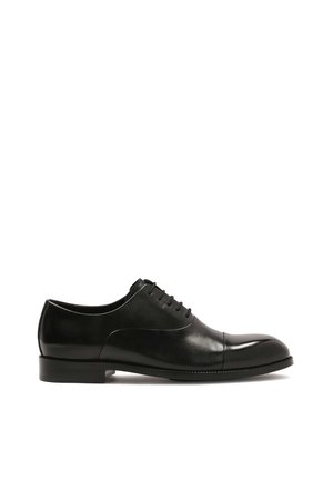 Zapato de vestir negro de cuero con punta redonda, superficie lisa, costura mínima y cierre con cordones. Tacón plano y acabado pulido.