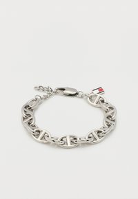 Ασημένιο βραχιόλι αλυσίδα με γυαλιστερές οβάλ συνδέσεις και κούμπωμα καβουριού, με ένα μικρό ορθογώνιο μενταγιόν με κόκκινες, άσπρες και ναυτικές ρίγες.