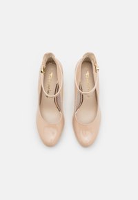 Bežové lakové lodičky se zaoblenou špičkou a popruhem kolem kotníku, se zlatou sponou a polstrovanou stélkou. Velikost 37.