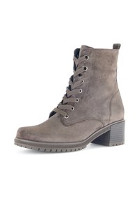 Stivale alla caviglia in suede marrone con design con lacci, punta tonda e tacco a blocco. Presenta una suola in gomma grigia e un occhiello per una facile calzata.