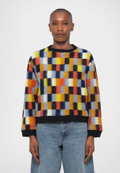 Multicolored knit sweater featuring a bold geometric pattern of squares in yellow, red, blue, and orange. Black trim at neckline and cuffs.