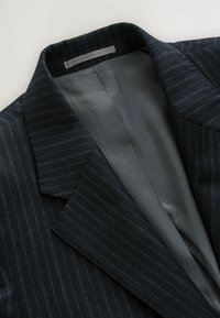 Czarny granatowy żakiet w paski z kołnierzem z wycięciem, z gładką szaro-srebrną podszewką i delikatnymi prążkami. Widoczne detale teksturowane.