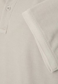 Lichtgrijze polo met een gestructureerde katoenmix, een placket met twee knopen en een eenvoudige kraag met gestikte randdetails.