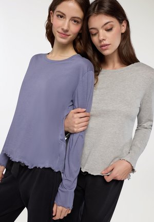 Due camicie a maniche lunghe: una in morbido lavanda con orlo e maniche scalloppati, l'altra in grigio, entrambe con una vestibilità comoda e tessuto leggero.