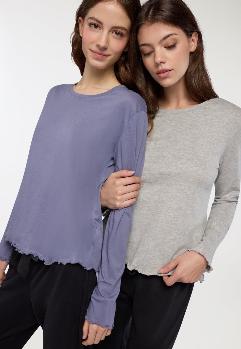 Due camicie a maniche lunghe: una in morbido lavanda con orlo e maniche scalloppati, l'altra in grigio, entrambe con una vestibilità comoda e tessuto leggero.