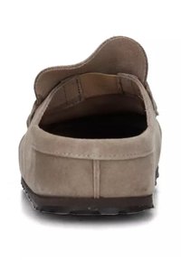 Mocassino in suede marrone chiaro con tallone arrotondato, dettagli cuciti e suola in gomma nera testurizzata. Design aperto con decorazioni minime.