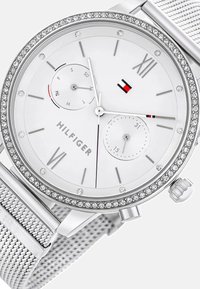 Orologio in acciaio inossidabile argentato con quadrante bianco, decorazioni in cristallo, cinturino a rete, numeri romani e tre sottodial per la gestione del tempo.