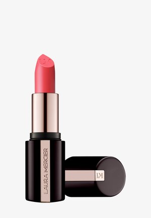 Rouge à lèvres Laura Mercier dans une teinte rose corail avec un tube noir et rose doré, capuchon placé à côté de la base, LM gravé sur le bout du rouge à lèvres et le capuchon.