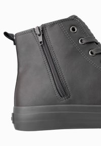 Zapatillas altas grises hechas de cuero sintético con un zipper lateral, superficie texturizada, costuras reforzadas y suela gruesa de goma.