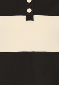 Polo de rayas negras y crema, con un cuello de tres botones, textura suave y bloques de color horizontal en contraste.