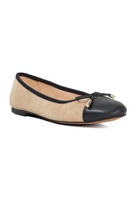 Balletflats in beige suède met een zwarte leren neus. Geëquipeerd met een zwarte bies en een klein strikdetail met gouden hardware accenten.