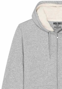 Felpa grigia con zip frontale, morbida fodera in pile bianco nel cappuccio e lacci. Presenta una tasca a marsupio e polsini a coste.