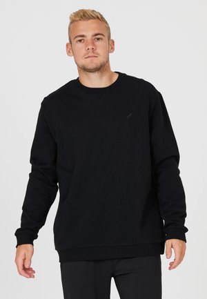 Sort sweatshirt med lange ærmer og ribbede manchetter og kant. Har et diskret logo på brystet. Fremstillet af et tekstureret stof.