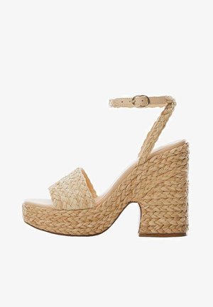 Sandale plateforme beige en tissu tressé avec talon haut épais, bout ouvert et bride de cheville ajustable avec boucle dorée.