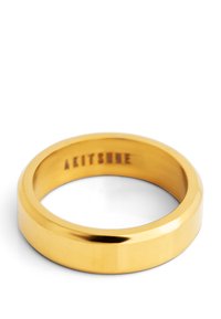 Anello in metallo dorato con una finitura liscia e lucida. Design a banda piatta, con un interno inciso con "AKITSUNE."