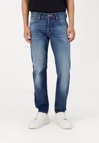 Lyseblå denimjeans med rett ben-design, som har fem lommer, knappestolpe og subtil falming på lårene.