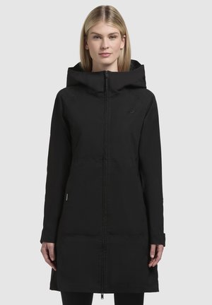 Parka nera isolata con zip frontale, grande cappuccio, maniche lunghe e orlo leggermente svasato. Texture liscia e branding minimal.