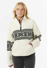 Fleece pullover met een ritskraag, crème kleur, zwart patroon met krullen en ruitjes, en zijzakken. Zachte textuur.
