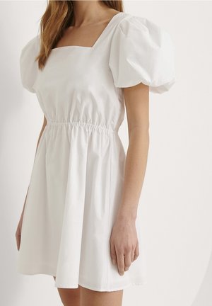 Hvid kjole med firkantet udskæring, pufærmer og syet talje. Fremstillet i let stof, den har en afslappet pasform og en udvidet nederdel.