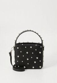 Svart läderväska med en strukturerad form, prydd med silvernitar, utrustad med ett handtag upptill och avtagbar axelrem.