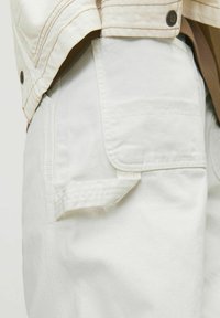 White cargo pants with a side pocket, made of thick fabric. The pants have a smooth texture and feature contrasting stitching details.