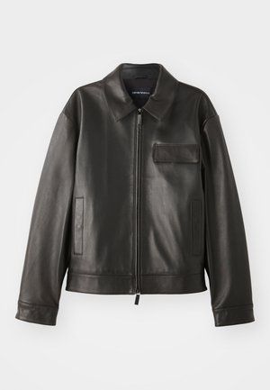 Chaqueta de cuero negro con cuello, cremallera frontal y dos bolsillos laterales. Presenta un bolsillo en el pecho con detalle de solapa y textura suave.