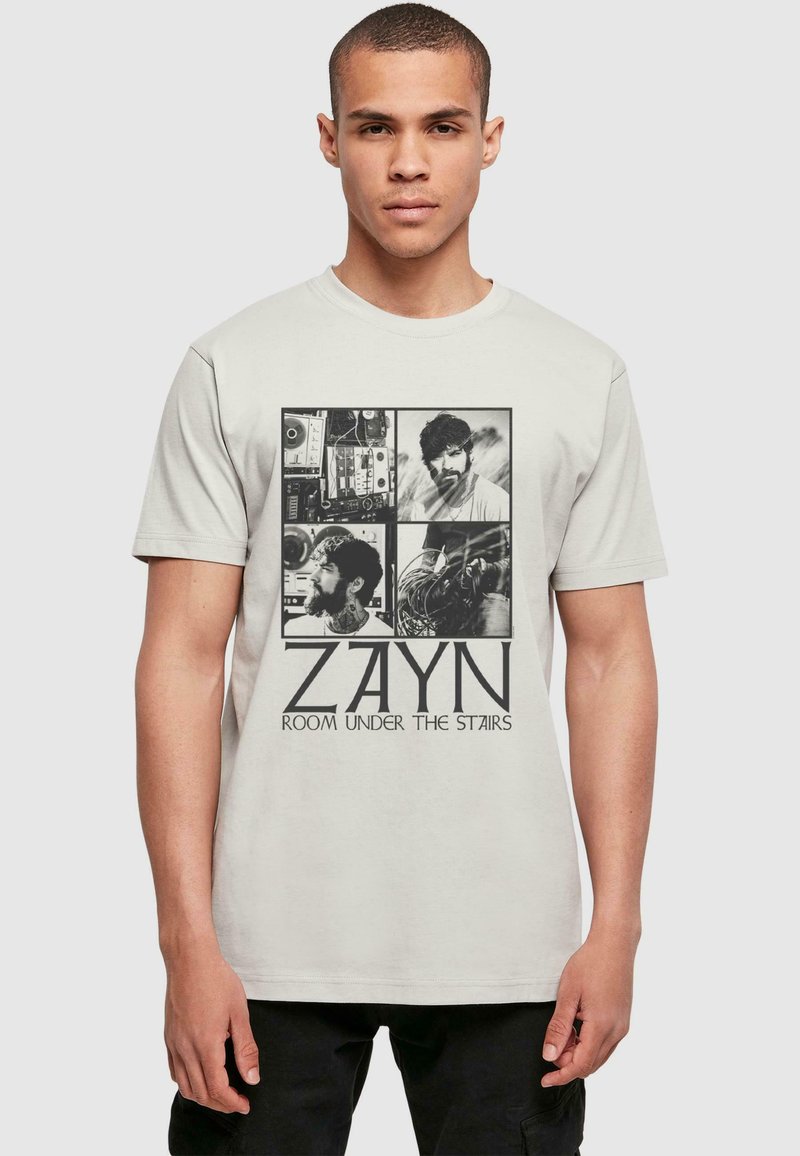 Tejfehér pamut póló, fekete grafikai képekkel és "ZAYN ROOM UNDER THE STAIRS" felirattal. Klasszikus szabású, rövid ujjú és bordázott nyakkivágással.