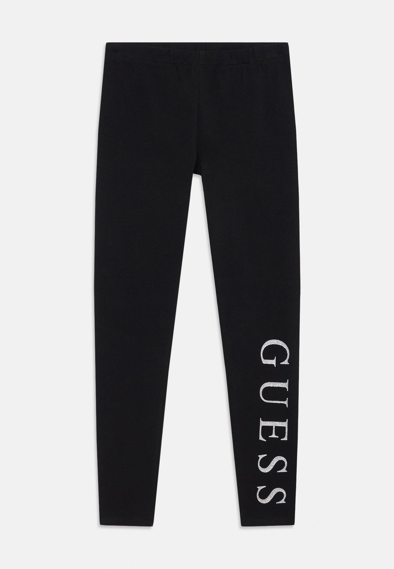 Leggings neri realizzati in tessuto elasticizzato, con il logo "GUESS" stampato in verticale sulla gamba sinistra. Comprendono una vita elasticizzata.