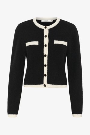 Čierny huňatý kardigán s bielou lệzbdou a vreckovými akcentami. Obsahuje čierne gombíky a skrátený strih s dlhými rukávmi.