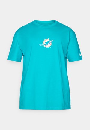 Turkis bomull t-skjorte med rund hals og korte ermer. Har et delfinlogo omgitt av et soldesign på forsiden. Nike swoosh på ermet.