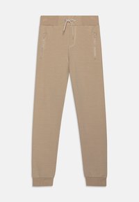 Beige Sweatpants aus weichem Stoff, mit einem Kordelzugbund, seitlichen Reißverschlüssen und eng anliegenden Bündchen. Minimalistisches Design ohne Muster.