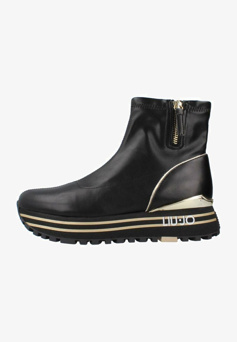 Stivale alla caviglia in pelle nera con chiusura a zip, accenti in metallo dorato e una suola a piattaforma stratificata con strisce dorate e nere.