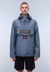 Blauwe pullover jas met hoge kraag, voorkantzak, geborduurd logo en detail van de Noorse vlag. Gemaakt van glad, lichtgewicht materiaal.
