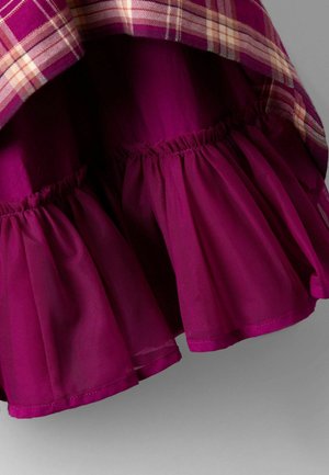 Blommefarvet kjole med et plisseret lag og et ternet stof i kanten, lavet af et letvægtsmateriale med en sammenkrøllet tekstur.