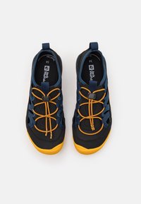 Black and navy slip-on shoes with orange laces, featuring a textured rubber sole and cut-out side panels for breathability.